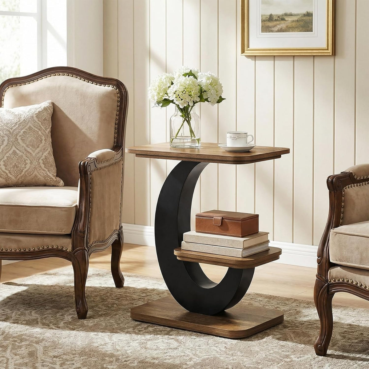 Black metal side table with two wood-grain tiers beside a cream armchair