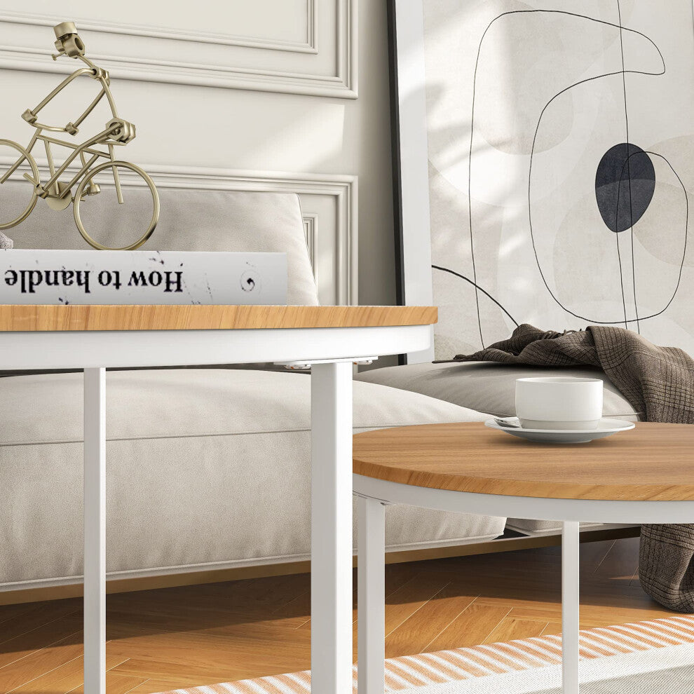 Close-up of light oak-effect round coffee table top and slim white metal legs