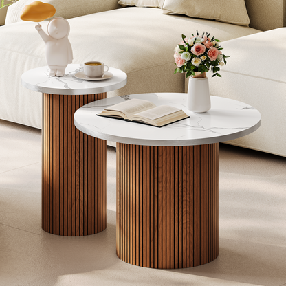 Close-up of white marble-effect round tops with brushed silver edge on fluted bases