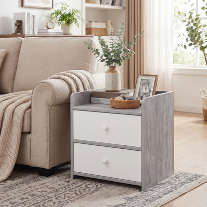 Grey drawer side table beside a cream sofa with eucalyptus vase and photo frame