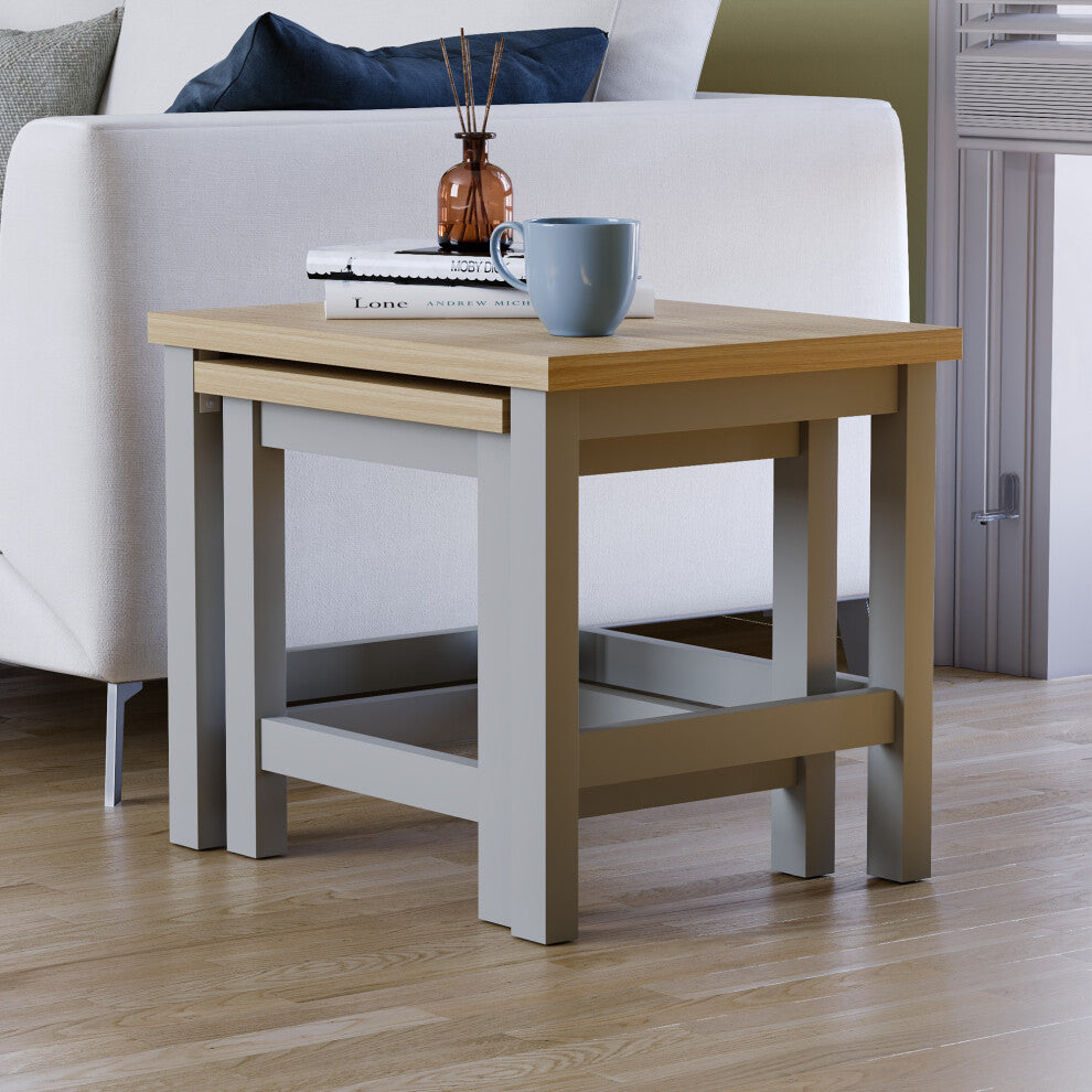 Grey oak-effect nest of tables fully nested, the small table tucked under the large one beside a sofa