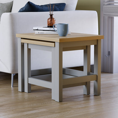 Grey oak-effect nest of tables fully nested, the small table tucked under the large one beside a sofa