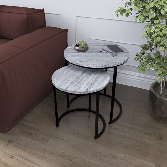 Grey wood-effect round nesting side tables with black metal frames beside a burgundy sofa