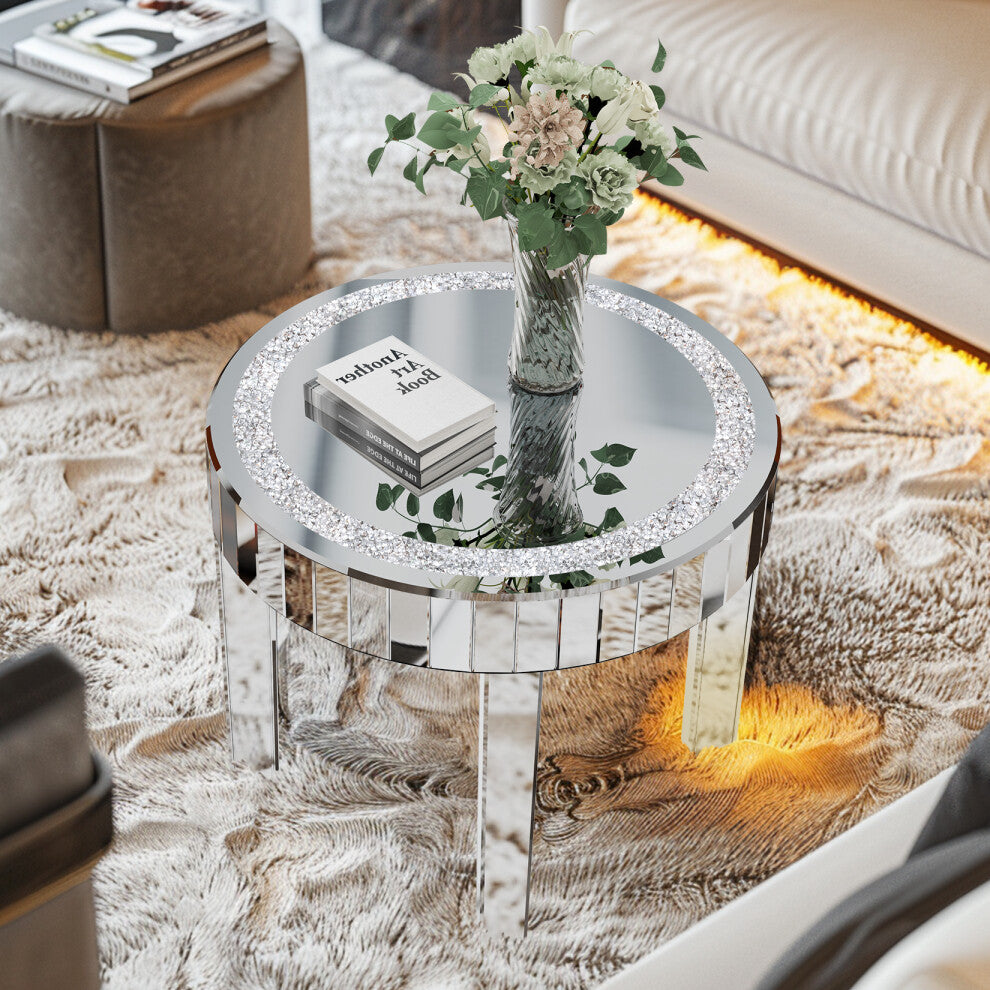 Mirrored round coffee table with sparkling crushed crystal ring styled with a vase of flowers and art books on a textured rug