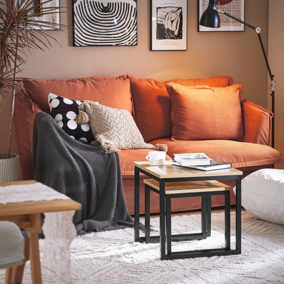 Oak-effect square nesting tables fully nested beside an orange sofa with a mug and books on top