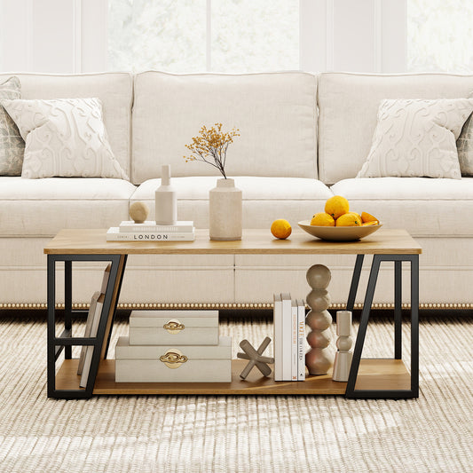 Rectangular coffee table with storage shelf, oak-tone top and black angled metal frame in front of a cream sofa
