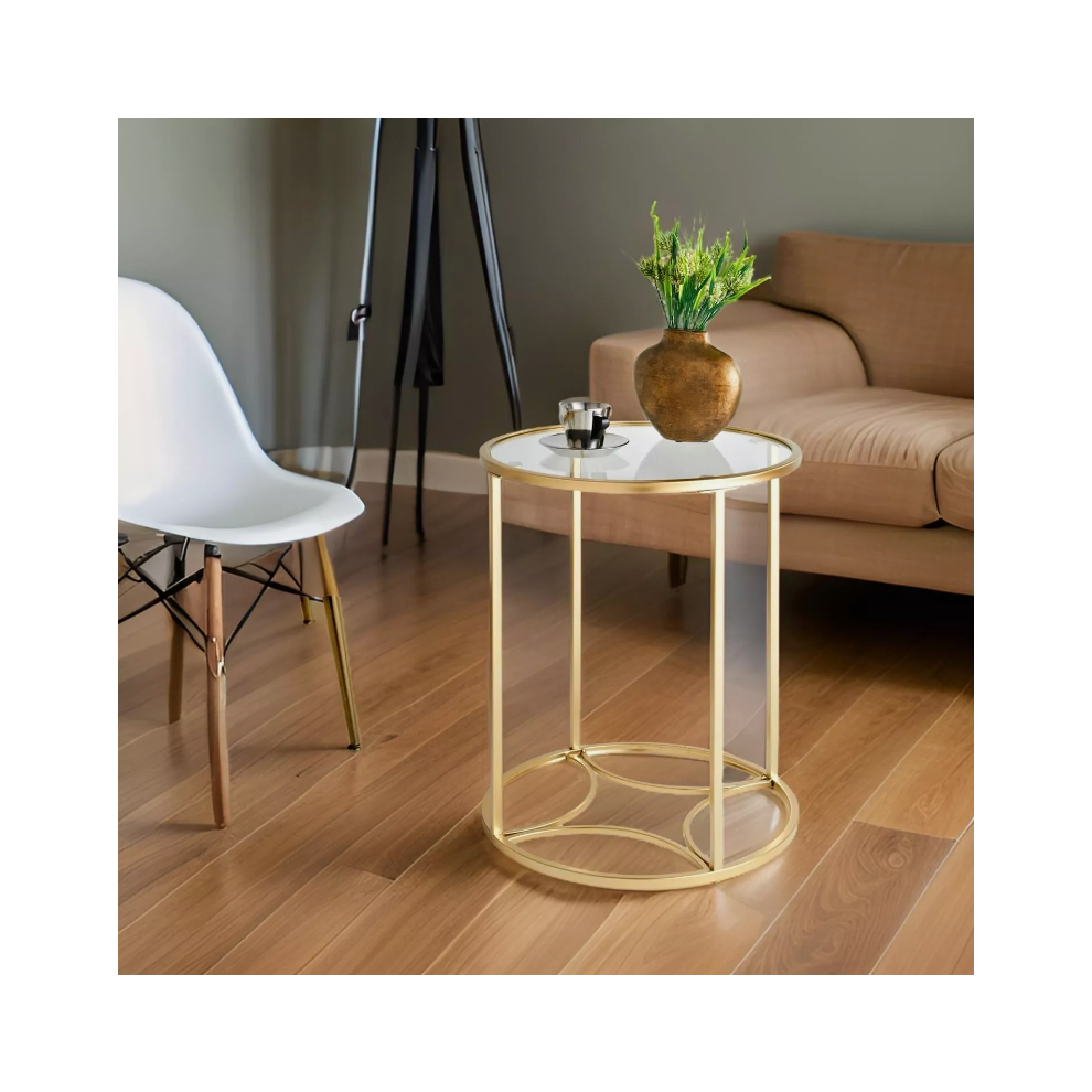 Round gold glass end table with vase and espresso cup next to a camel sofa in a modern living room