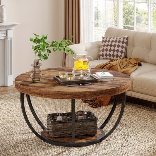 Rustic round coffee table with shelf, brown wood-effect top and curved black frame beside a cream sofa
