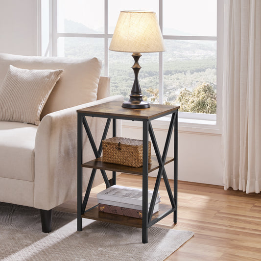 Rustic side table with three brown shelves and black X-frame sides beside a sofa with a table lamp