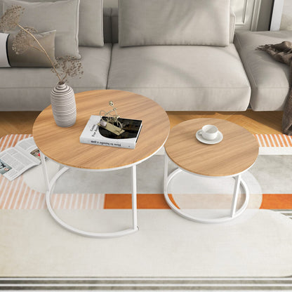 Set of 2 round wooden coffee tables with light oak-effect tops and white metal frames in a Scandi living room