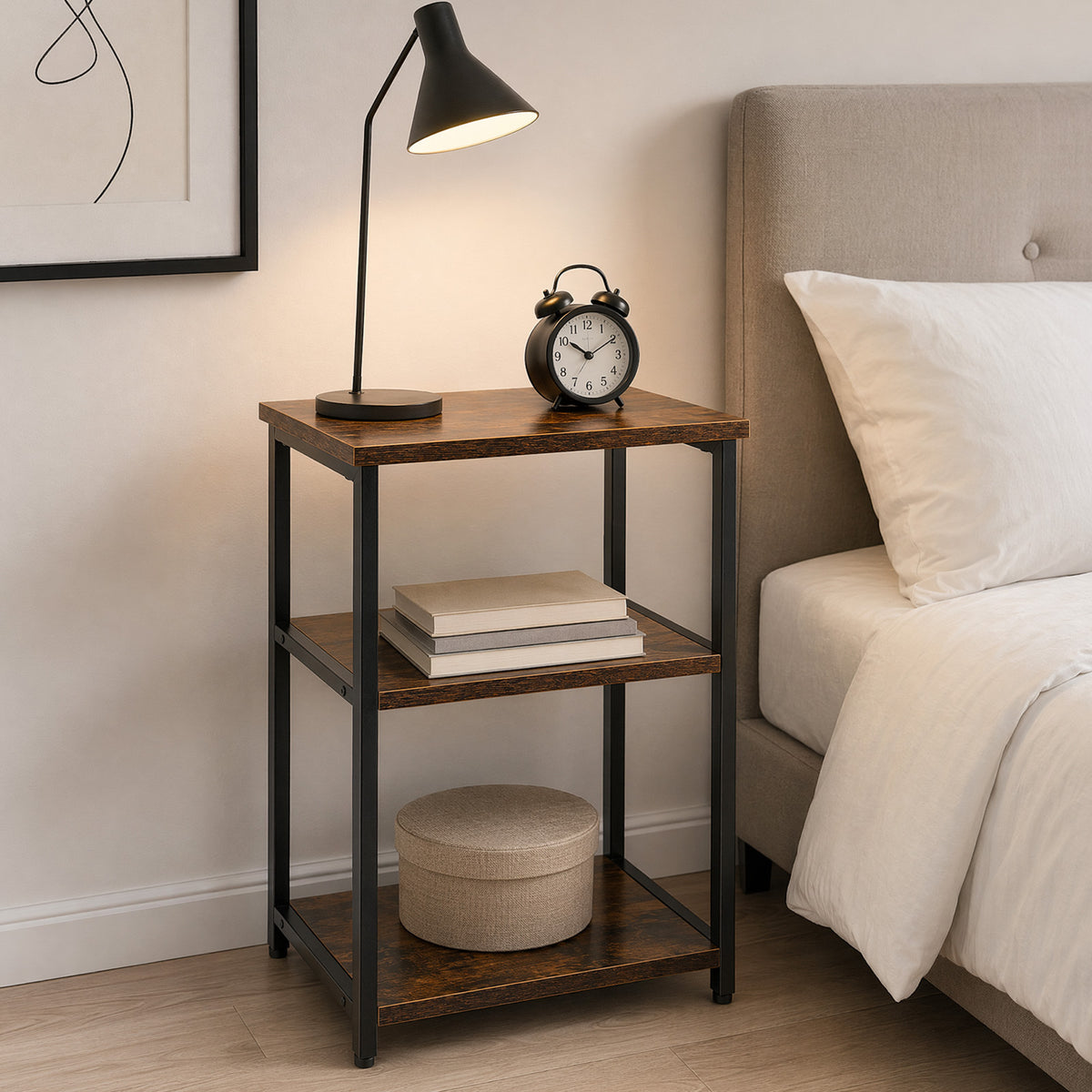 Slim 3-tier end table used as a bedside table with lamp and clock