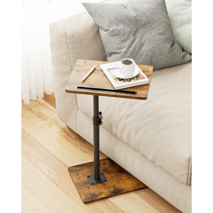 Small dark wood effect coffee table over a sofa seat with a coffee cup and book
