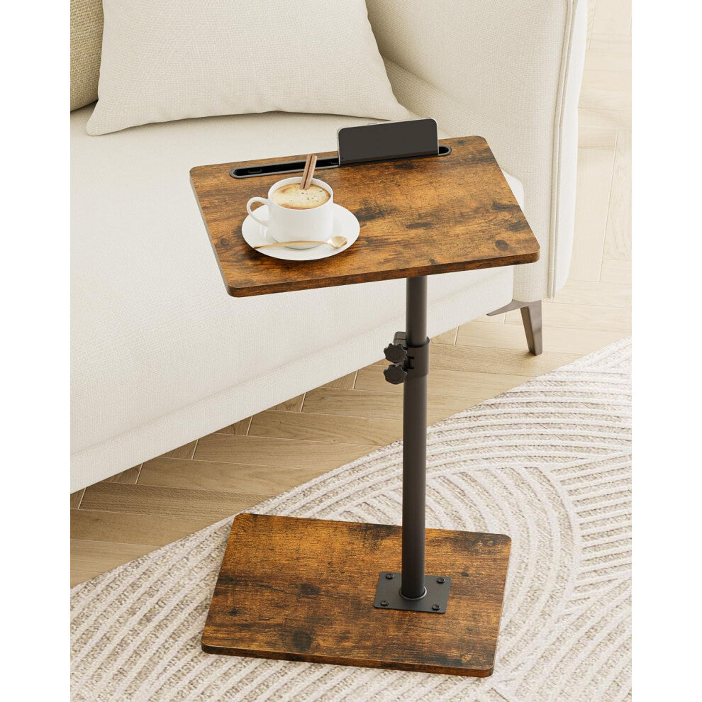 Small wood coffee table in rustic brown effect with black pole and phone slot beside a cream sofa