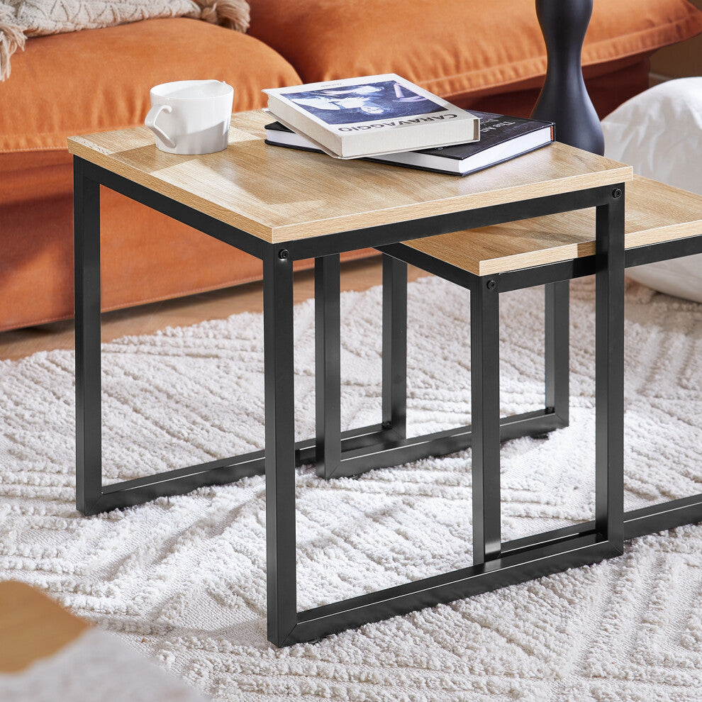 Close-up of the oak-effect tops and black metal U-frames of the square nest of tables on a white rug