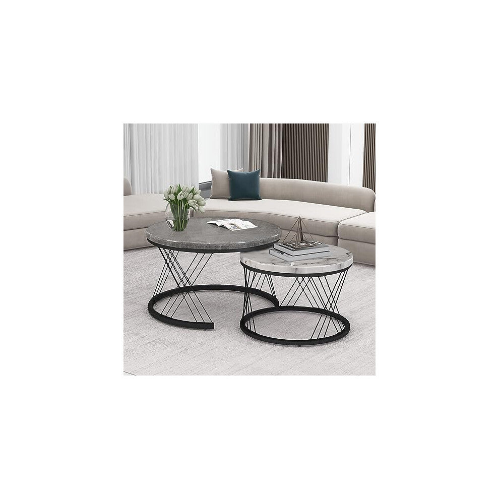 Two-tone round nesting coffee tables styled with tulips beside a curved beige sofa