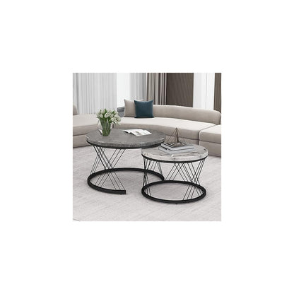 Two-tone round nesting coffee tables styled with tulips beside a curved beige sofa