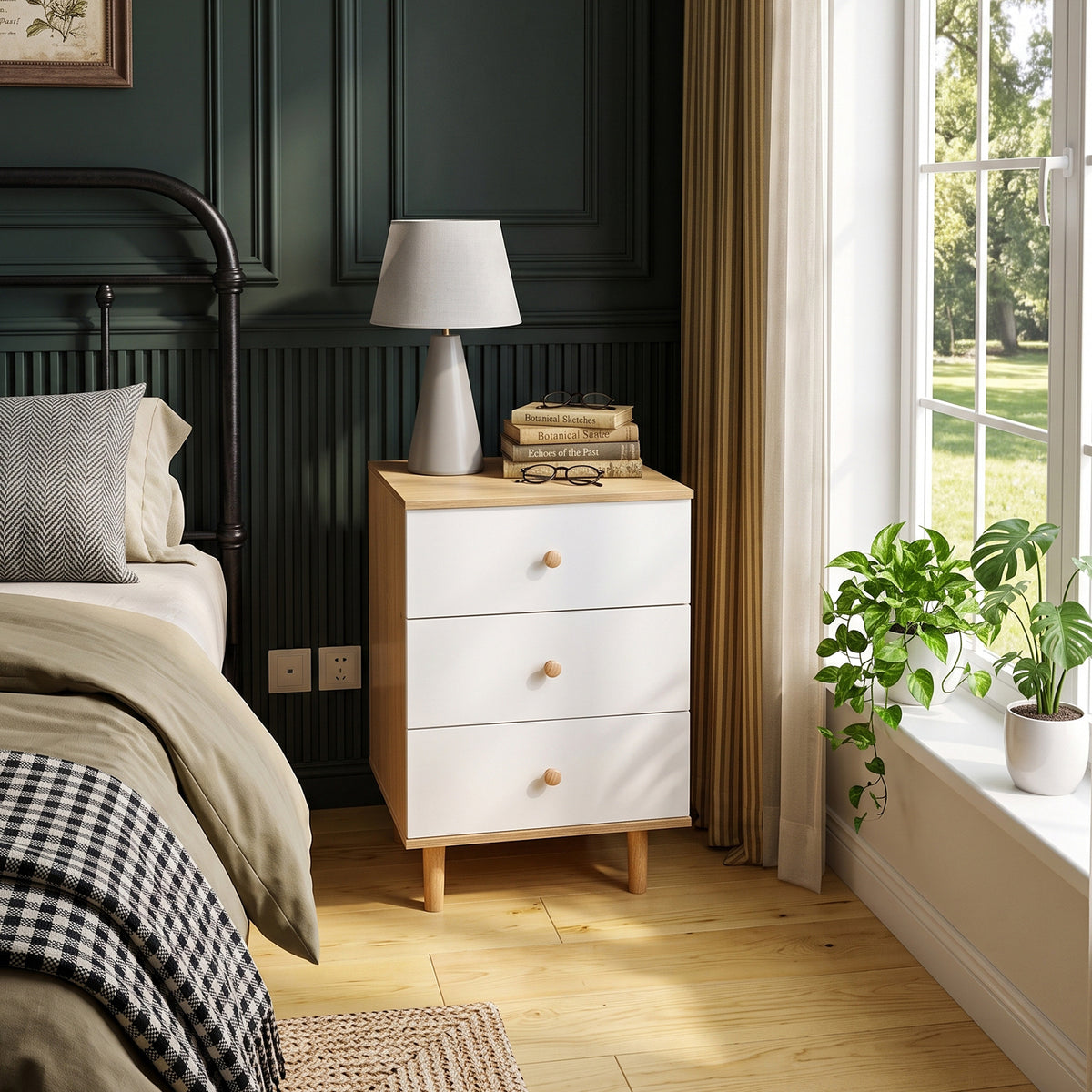 White three-drawer bedside cabinet in a dark green bedroom