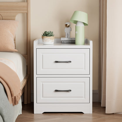 White bedside table with black handles and a lamp on top