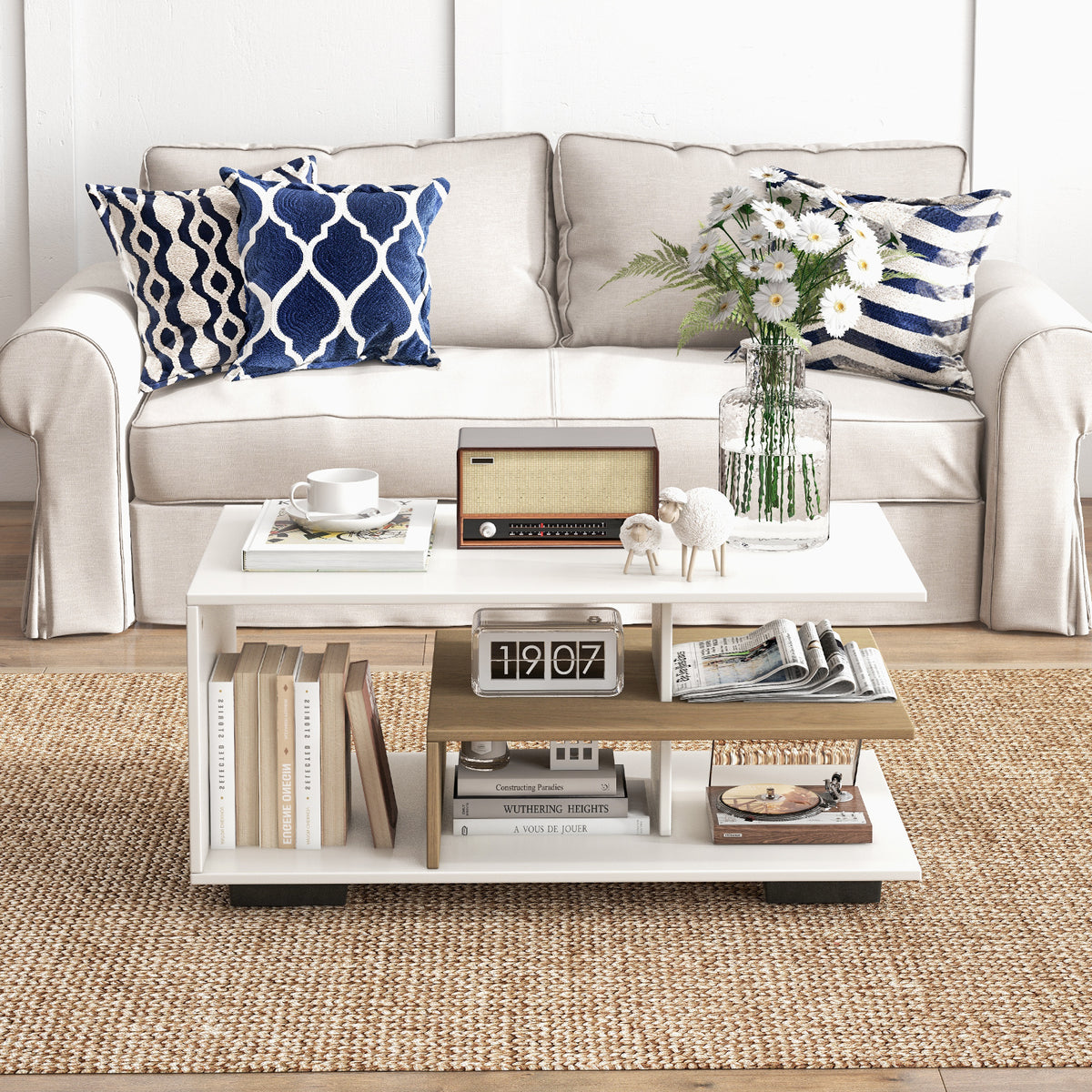 White 3-tier geometric rectangular coffee table with oak-tone shelf in front of a cream sofa