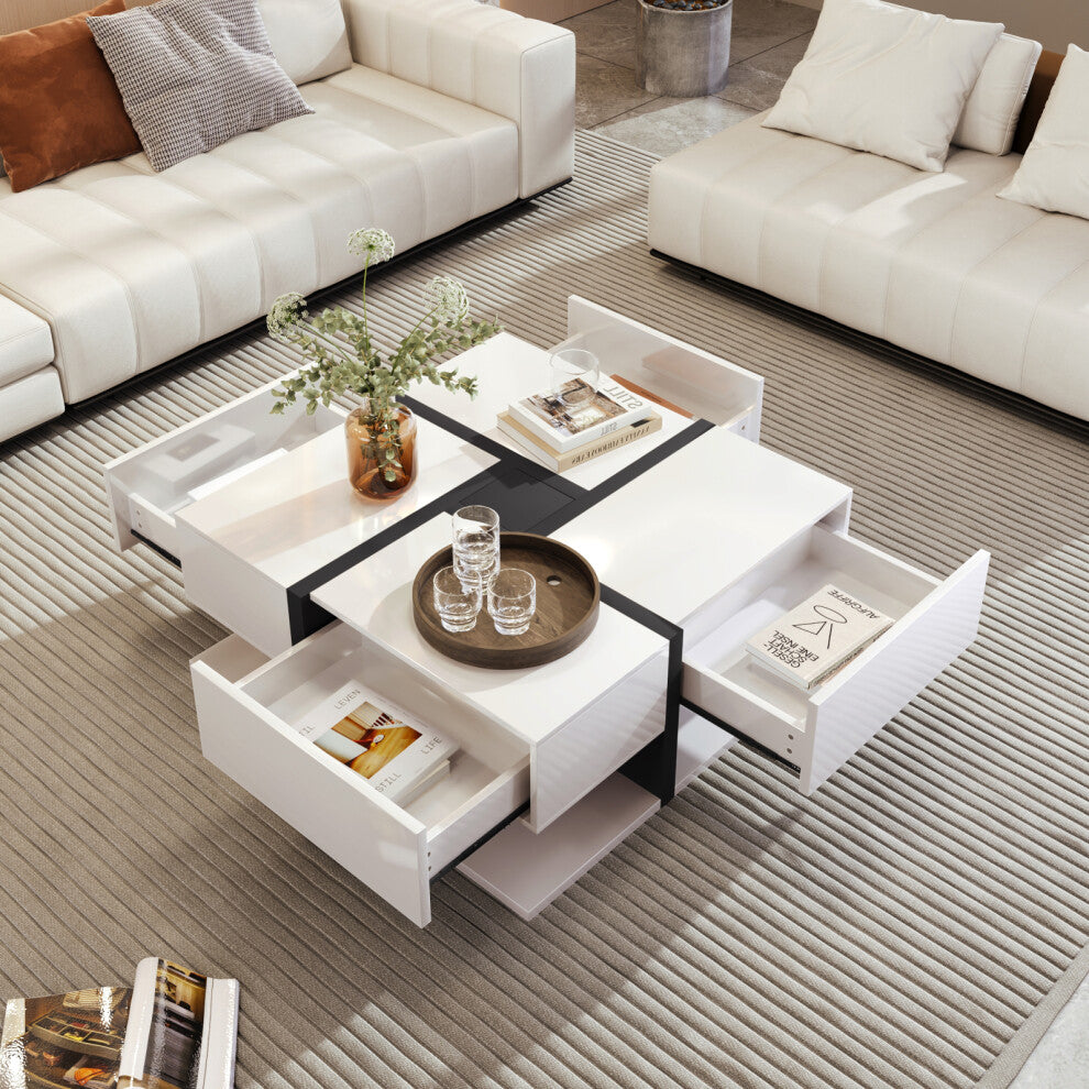 White gloss square coffee table with all four drawers open and black cross detail between two cream sofas
