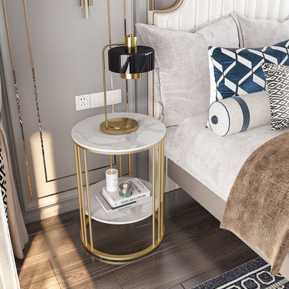 White marble-effect and gold round side table used as a nightstand with brass lamp