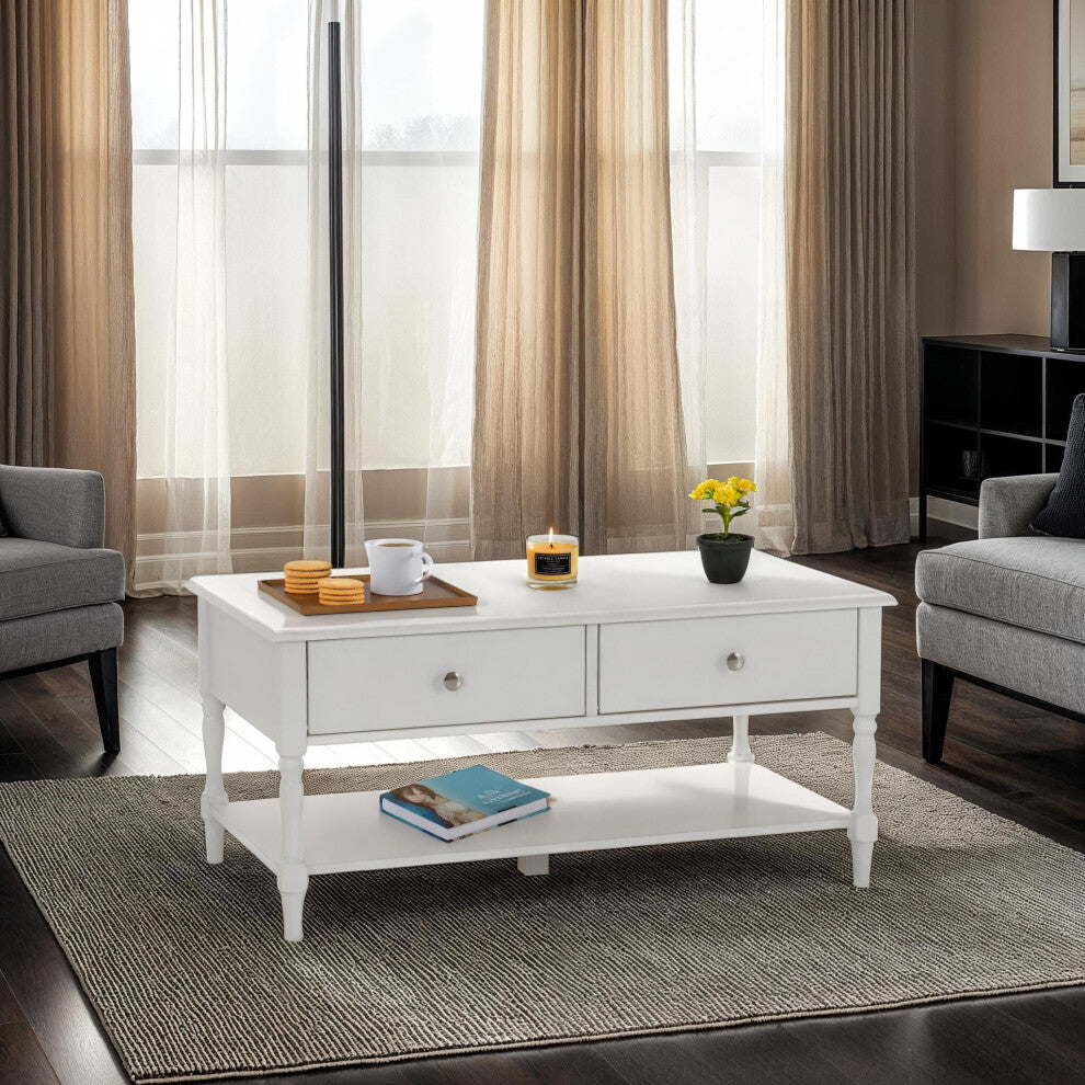 White traditional coffee table with two drawers and lower shelf between grey armchairs