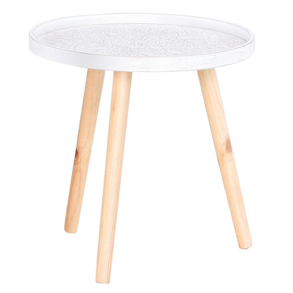 Whitewashed round side table with carved mandala top and three solid wood legs on a white background